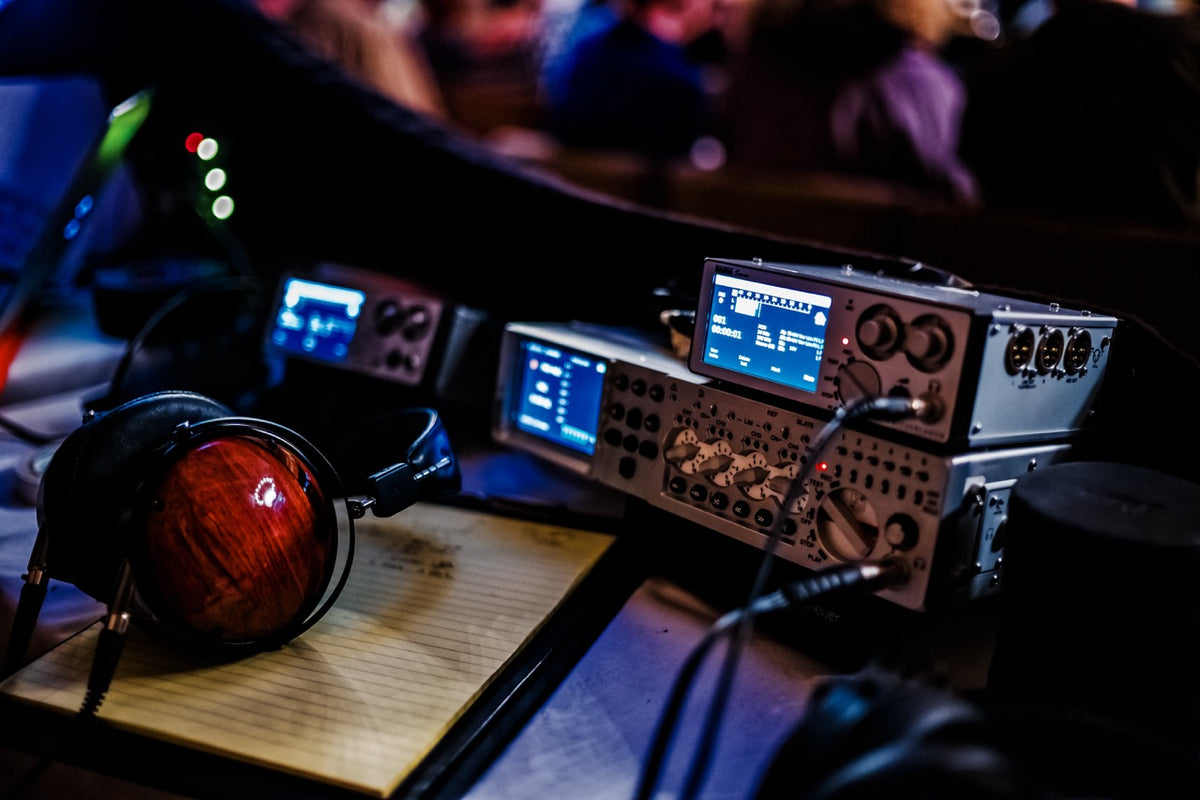 Nagra Audio equipment with headphones on a wooden surface in a blurred indoor setting